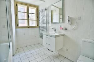 a white bathroom with a sink and a mirror at U Schnellu in Prague