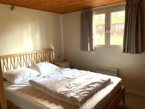 a bed in a bedroom with a window at Familie Meys Chalets - Chalet 249 - La Boverie in Rendeux