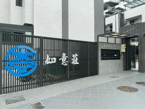 竹山7號民宿 في Kuei-lin-li: حاجز أسود عليه لافتات بجانب مبنى