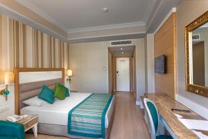 a hotel room with a bed and a mirror at Karmir Resort & Spa - Ultra All Inclusive in Kemer