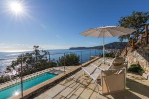 a house with a swimming pool and an umbrella at La Sterlizia di Santa Croce in Alassio