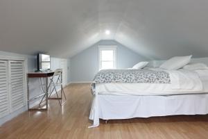 a white bedroom with a bed and a desk at Best Home To Visit NYC+Hot Tub+EWR Airport+Free Parking in Hillside