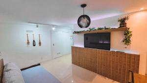 a living room with a flat screen tv on a wall at Ap Anjos de Arraial - Residencial de frente para a Praia dos Anjos - Arraial do Cabo in Arraial do Cabo