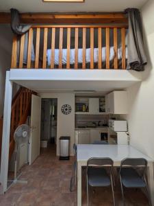 ein Hochbett mit einem Tisch und Stühlen in einem Zimmer in der Unterkunft MARINES DU ROUSSILLON Villa en résidence avec piscine à 150 m de la plage v100 in Saint-Cyprien