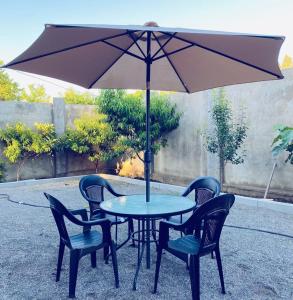 een tafel met vier stoelen en een paraplu bij Диас in Soechoemi