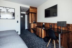 a hotel room with a bed and a desk and a television at Hotel Grauer Bär in Innsbruck