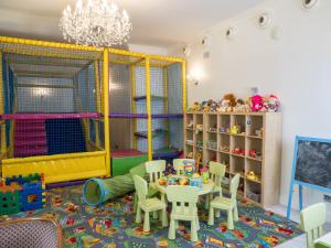 a childs play room with a table and chairs and a play set at Hotel Sobienie Królewskie in Sobienie Szlacheckie