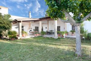 a white house with a tree in the yard at Villa Delle Palme in Trepuzzi