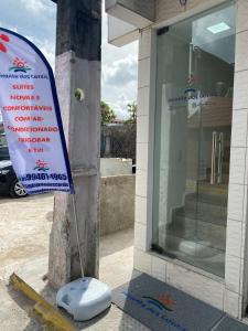 una señal en el lateral de un edificio junto a una ventana en Mirante dos Corais, en Porto de Galinhas