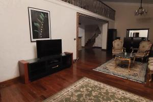 a living room with a flat screen tv and a couch at Spacious cheerful apartment in Cairo