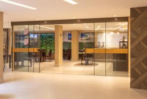 a lobby with glass doors and a dining area at Hotel Annamar Premium in João Pessoa