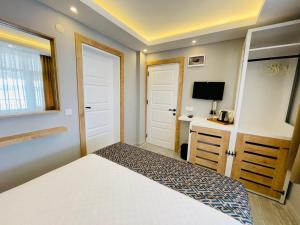 a small bedroom with a bed and a desk at YALI PANSİYON in Kas