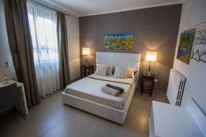 a bedroom with a white bed and a window at B&B Le Muse in Mondello