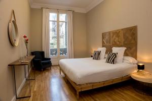 a bedroom with a bed and a chair and a window at Cami Gallery Barcelona in Barcelona