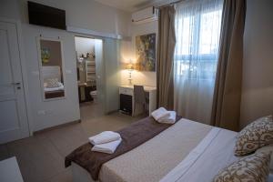 a hotel room with two beds and a television at B&B Le Muse in Mondello