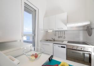 a kitchen with white appliances and a bowl on a counter at Apartment Arte Vrbnik in Vrbnik