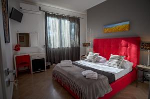 a bedroom with a large bed with a red headboard at B&B Le Muse in Mondello