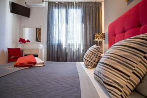 a bedroom with a large bed with a red headboard at B&B Le Muse in Mondello