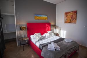 a bedroom with a large bed with a red headboard at B&B Le Muse in Mondello