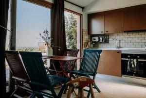 eine Küche mit 4 Stühlen, einem Tisch und einem Fenster in der Unterkunft Eco-lodge Villa Epicurea in Sesimbra