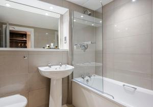 uma casa de banho com um lavatório, um WC e uma banheira em Hogs Back Hotel & Spa em Farnham