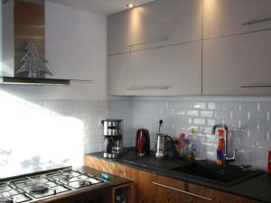 a kitchen with white cabinets and a stove top oven at Chalet Chamrousse, 5 pièces, 12 personnes - FR-1-340-211 in Chamrousse