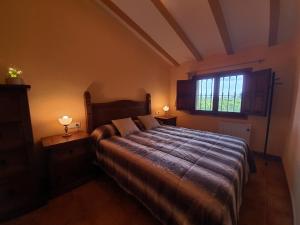 Riola的住宿－Villa Rural Reconstruida，一间卧室设有一张大床和一个窗户。