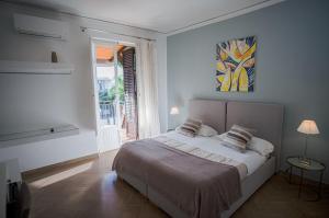 a white bedroom with a large bed and a window at B&B Le Muse in Mondello