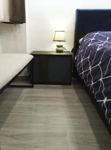 um quarto com uma cama e uma mesa com um candeeiro em Alex & Frank Apartment em Crotone