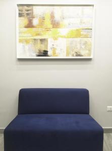 Niebieska ławka przed obrazem na ścianie w obiekcie Alex & Frank Apartment w mieście Crotone