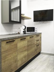 eine Küche mit einer Mikrowelle und einem TV auf der Theke in der Unterkunft Alex & Frank Apartment in Crotone