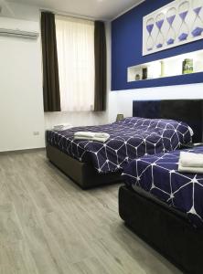 una camera con due letti e una parete blu di Alex & Frank Apartment a Crotone