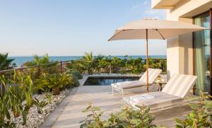 a patio with two chairs and an umbrella at Four Seasons Hotel Tunis in Gammarth