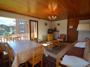 a living room with a table and a balcony at Appartement Courchevel 1850, 3 pièces, 6 personnes - FR-1-514-40 in Courchevel