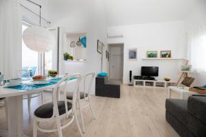 a white living room with a table and chairs at Apartment Arte Vrbnik in Vrbnik