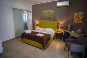 a bedroom with a bed and a desk and a chair at B&B Le Muse in Mondello