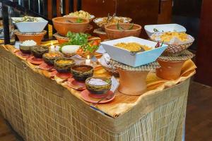 Sigiriya Melrose Villas في سيجيريا: طاولة مع أطباق من الطعام في الأعلى