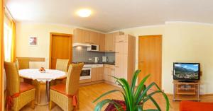 a kitchen with a table and chairs and a television at Dependance I in Schladming