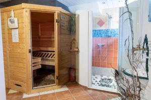 un armario de madera en el baño con ducha en Appartmenthaus Bachler, en Haus im Ennstal 35 fotos más