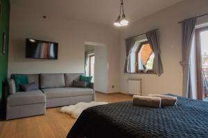a living room with a bed and a couch at KANIA Apartamenty - Zakopane in Zakopane
