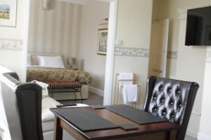 sala de estar con mesa y sofá en The Snowdonia Apartments, en Llandudno