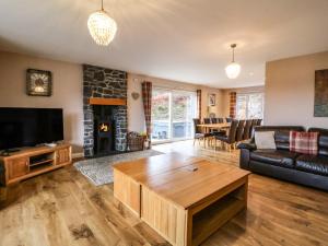 a living room with a couch and a fireplace at Holly House in Spean Bridge