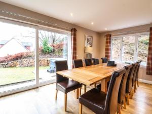 a dining room with a wooden table and chairs at Holly House in Spean Bridge