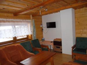 un soggiorno con tavolo, sedie e TV di Chata Sipkova I a Terchová