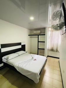 a bedroom with a white bed and a window at Gavan Plaza Hotel in Villavicencio