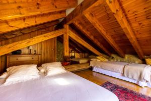 two beds in a room with wooden ceilings at Casa El Molí de Bor a Cerdanya in Bor