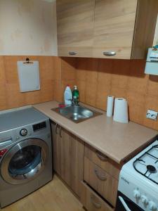 uma cozinha com um lavatório e uma máquina de lavar roupa em 1 room aprtment 400 from sea em Liepāja