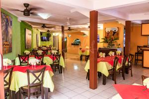 un ristorante con tavoli e sedie rossi e gialli di Tante Arlette a Grandʼ Rivière