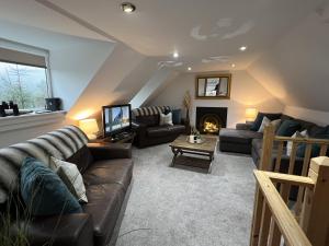 ein Wohnzimmer mit Couch und Kamin in der Unterkunft Hollybank Cottage in Lochgoilhead