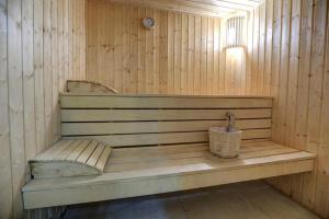 a wooden bench in a sauna with a bucket at Hotel Lalov Egrek in Lozenets